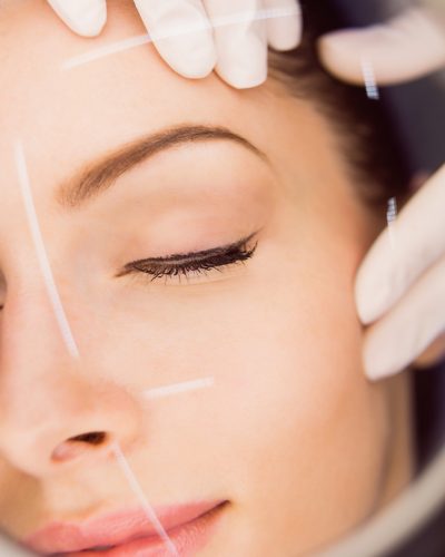 Dermatologist examining female patient skin in clinic